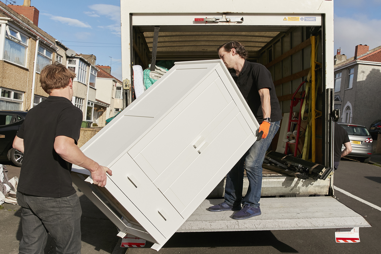 Labor Helpers loading a white chest into a box truck
